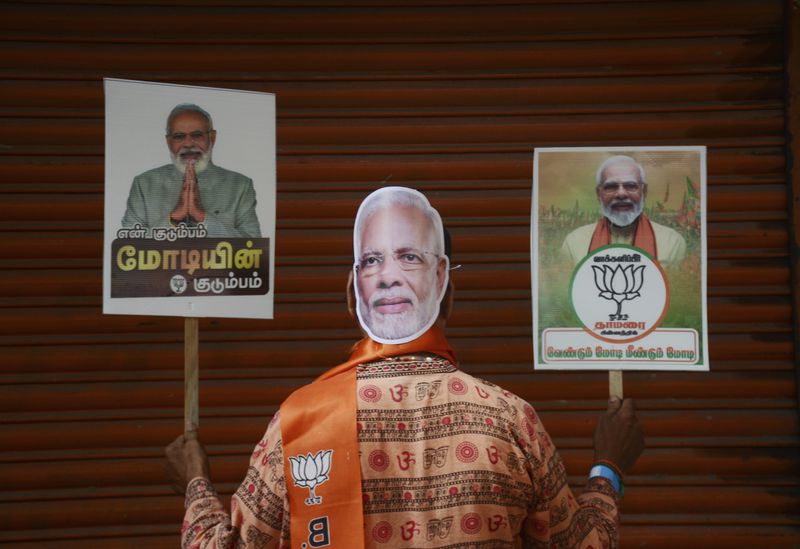 A Bharatiya Janata Party (BJP) supporter holds placards showing Prime Minister Narendra Modi during an election campaign in Chennai, India, Tuesday, April 9, 2024. In his coming term as prime minister, when he will need a coalition to govern after results announced on June 4 showed his Hindu nationalist party fell short of a majority, Modi may have to adapt to a style of governance he has little experience in, or desire for. (AP Photo)