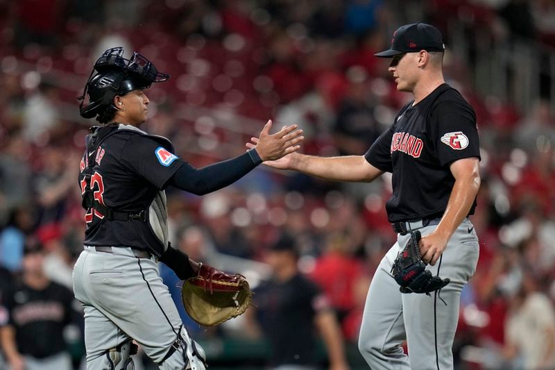 Cleveland Guardians relief pitcher Erik Sabrowski, right, and catcher Bo Naylor celebrate a 5-1 victory over the St. Louis Cardinals in a baseball game Friday, Sept. 20, 2024, in St. Louis. (AP Photo/Jeff Roberson)