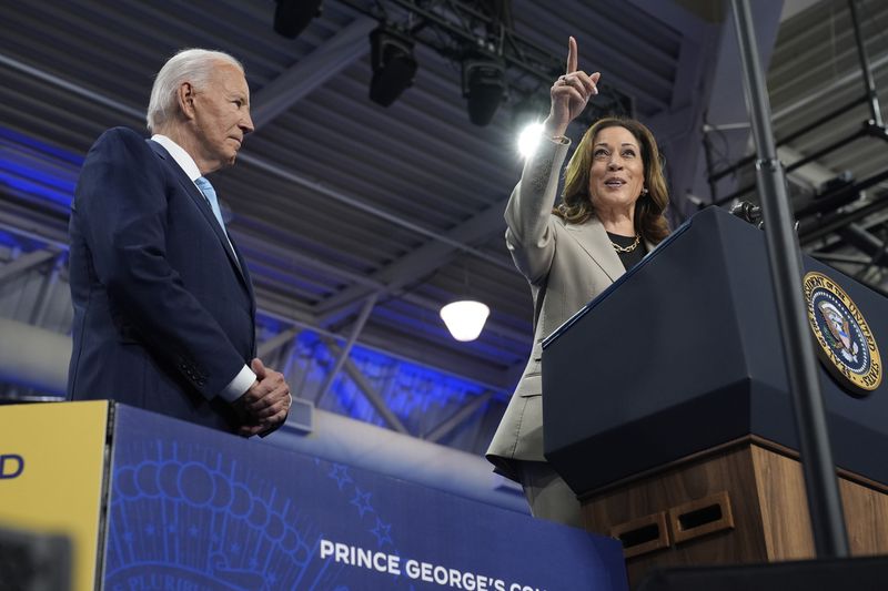 President Joe Biden, left, listens as Democratic presidential nominee Vice President Kamala Harris speaks about the administration's efforts to lower prescription drug costs during an event at Prince George's Community College in Largo, Md., Thursday, Aug. 15, 2024. (AP Photo/Susan Walsh)