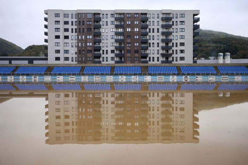 Apartment buildings are reflected at a flooded soccer field after a heavy rain in the village of Kiseljak, northern Bosnia, Friday, Oct. 4, 2024. (AP Photo/Armin Durgut)