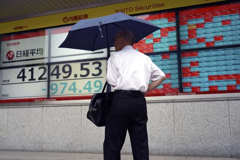 A person stops to look at an electronic stock board showing Japan's Nikkei index at a securities firm Friday, July 12, 2024, in Tokyo. (AP Photo/Eugene Hoshiko)