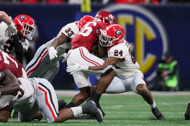 Georgia Bulldogs defensive back Malaki Starks (24) and Georgia linebacker C.J. Allen (33) tackle Alabama Crimson Tide running back Jam Miller (26) during the SEC Championship football game at the Mercedes-Benz Stadium in Atlanta, on Saturday, December 2, 2023. (Jason Getz / Jason.Getz@ajc.com)