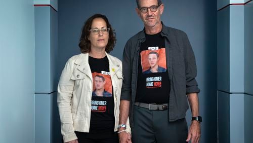 Orna Neutra, left, and her husband Ronen Neutra, of Long Island, N.Y., whose son Omer Neutra, 22, is being held hostage by Hamas in Gaza, hold hands while posing for a portrait, after families of Americans being held hostage in Gaza by Hamas were interviewed, Wednesday, June 5, 2024, by the Associated Press in Washington. The couple wears tape with the number of days that their son has been hostage. (AP Photo/Jacquelyn Martin)