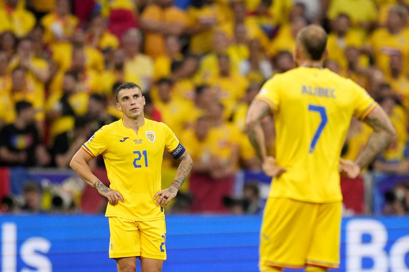 Romania's Nicolae Stanciu, left, and his teammates react after Donyell Malen of the Netherlands scored his side's second goal during a round of sixteen match between Romania and the Netherlands at the Euro 2024 soccer tournament in Munich, Germany, Tuesday, July 2, 2024. (AP Photo/Manu Fernandez)