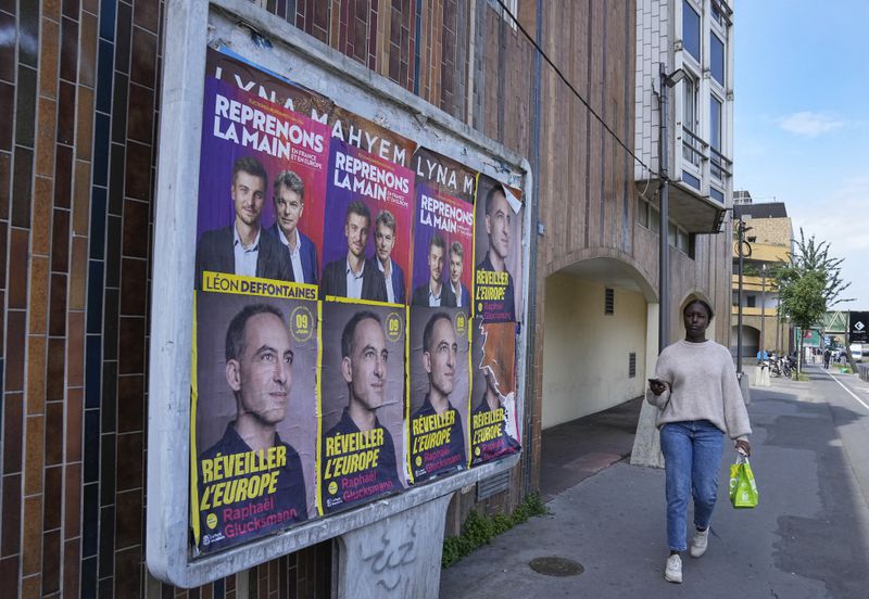 A woman walks past campaign posters for the upcoming European election in Colombes, west of Paris, Thursday, June 6, 2024. The European Election will take place on June 9. (AP Photo/Michel Euler)