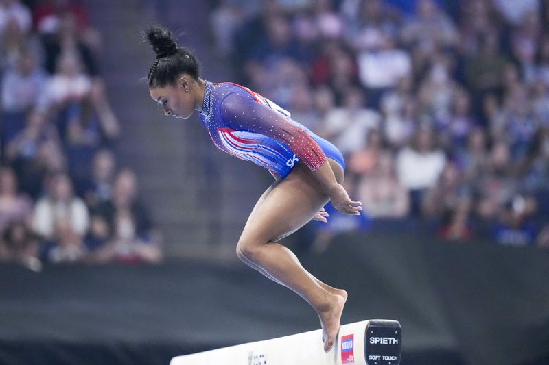 Simone Biles bobbles and falls off the balance beam at the United States Gymnastics Olympic Trials on Sunday, June 30, 2024, in Minneapolis. (AP Photo/Charlie Riedel)