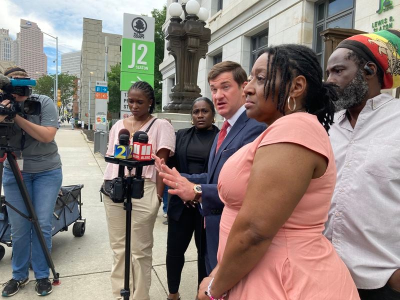 Attorney Parker Miller (center) and Mari Creighton's parents, Tracey Eason and Juan Umberto Creighton (far right), outside the Fulton County Courthouse.