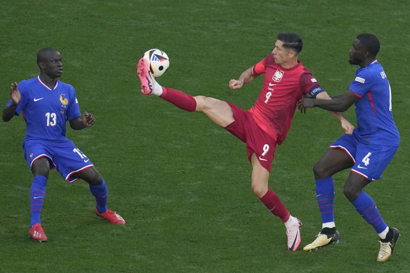 Poland's Robert Lewandowski fights for ball against Dayot Upamecano and N'Golo Kante of France during a Group D match between the France and Poland at the Euro 2024 soccer tournament in Dortmund, Germany, Tuesday, June 25, 2024. (AP Photo/Themba Hadebe)