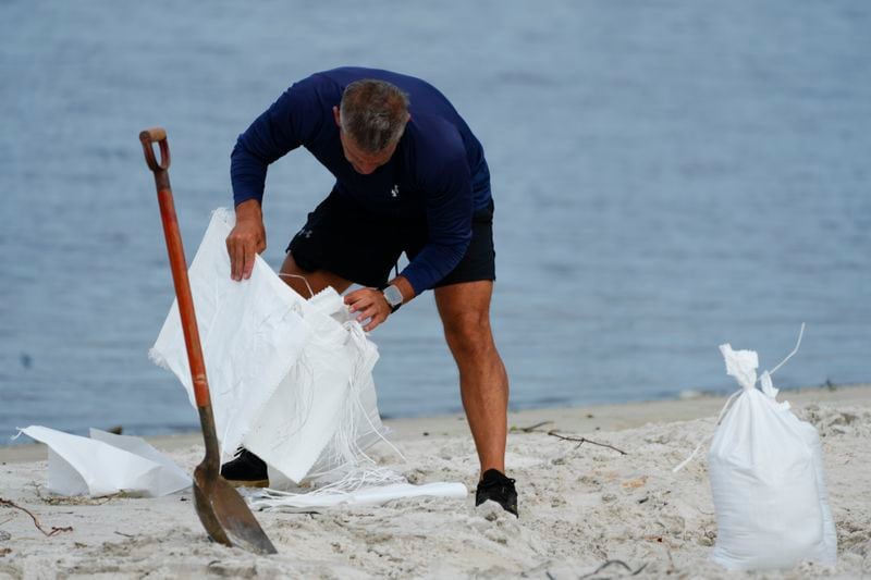 A person fills sand bags on the beach at the Davis Islands Yacht Basin while preparing for the arrival of Hurricane Milton, Tuesday, Oct. 8, 2024, in Tampa, Fla. (AP Photo/Julio Cortez)