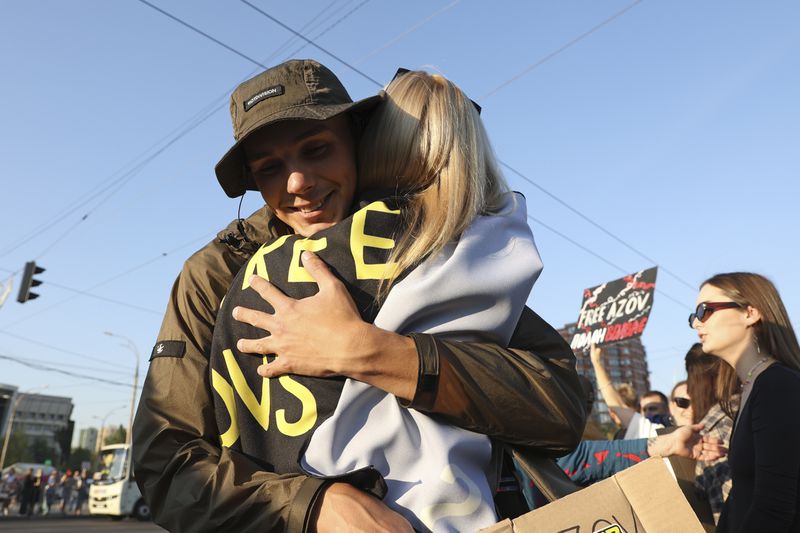 Anatolii Mikheev, a former Azovstal fighter who was recently released in a prisoner exchange, is embraced as he participates in the weekly protest in Kyiv, Ukraine, Sunday Sept. 22, 2024 concerning the plight of Ukrainian Azovstal defenders still being held prisoner by the Russians. (AP Photo/Anton Shtuka)