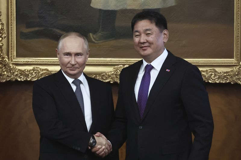 Russian President Vladimir Putin and Mongolian President Ukhnaagiin Khurelsukh shake hands as they pose for photos prior to the Russian-Mongolian talks at the Saaral Ordon Government Building in Ulaanbaatar, Mongolia, Tuesday, Sept. 3, 2024. (Sofia Sandurskaya, Sputnik, Kremlin Pool Photo via AP)