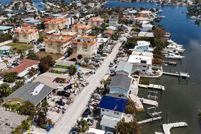 Contents of homes line the streets after flooding from Hurricane Helene on Wednesday, Oct. 2, 2024, in Reddington Shores, Fla. (AP Photo/Mike Carlson)