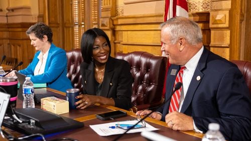 Georgia Election Board member Janelle King, center, speaks to executive director Mike Coan, right, before a board meeting at the Capitol in Atlanta on Friday, September 20, 2024. The election board is set to decide on sweeping rule changes less than a month before early voting begins. (Arvin Temkar / AJC)