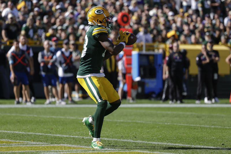 Green Bay Packers wide receiver Dontayvion Wicks (13) catches a touchdown pass in the end zone for a touchdown during the second half of an NFL football game against the Minnesota Vikings, Sunday, Sept. 29, 2024, in Green Bay, Wis. (AP Photo/Matt Ludtke)