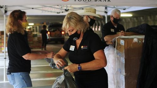 Gail Frantz, from Midwest Food Bank, packs bags of food during the Musically Fed food drive Oct. 29 at the Infinite Energy Center in Duluth, Georgia. Musically Fed, Rhino Staging, Midwest Food Bank and Infinite Energy Center hosted a drive-thru food distribution event for music and live entertainment industry workers in Atlanta. CHRISTINA MATACOTTA FOR THE ATLANTA JOURNAL-CONSTITUTION.