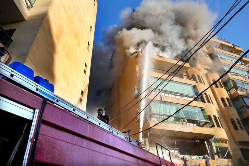 Civil defense firefighters try to extinguish the fire on an apartment following an Israeli airstrike in Dahieh, Beirut, Lebanon, Wednesday, Oct. 2, 2024. (AP Photo/Hussein Malla)