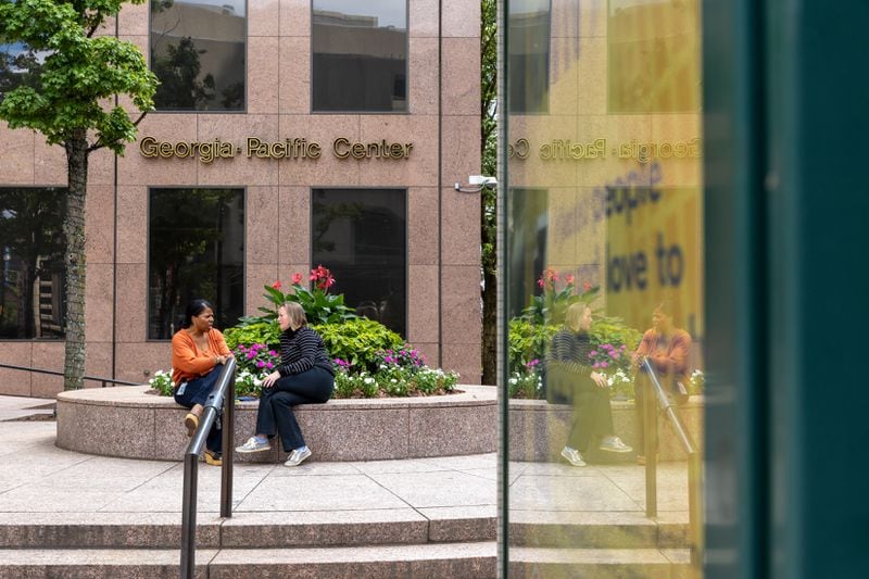 People sit in front of the Georgia-Pacific building in Atlanta on Wednesday,