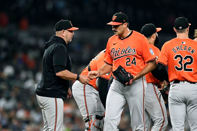 Baltimore Orioles manager Brandon Hyde, left, takes the ball from starting pitcher Zach Eflin (24) in the seventh inning of a baseball game against the Detroit Tigers, Friday, Sept. 13, 2024, in Detroit. (AP Photo/Jose Juarez)