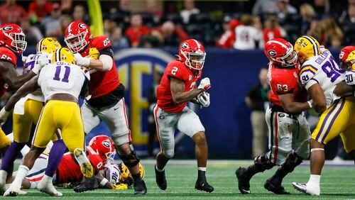 Georgia Bulldogs running back Kendall Milton (2) runs through a hole created by Georgia offensive lineman Tate Ratledge (69, left) and offensive lineman Sedrick Van Pran (63, right) for a 51-yard gain by Milton against the LSU Tigers during the second half of the SEC Championship Game at Mercedes-Benz Stadium in Atlanta on Saturday, Dec. 3, 2022. Georgia won 50-30. (Jason Getz / Jason.Getz@ajc.com)