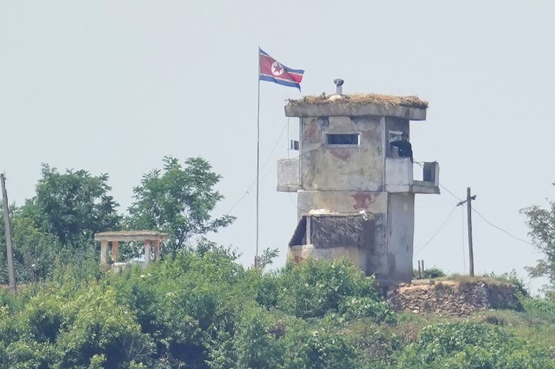 A North Korean soldier stands at the North's military guard post as a North Korean flag flutters in the wind, seen from Paju, South Korea, Wednesday, June 26, 2024. A suspected hypersonic missile launched by North Korea exploded in flight on Wednesday, South Korea's military said, a development that comes as North Korea is protesting the regional deployment of a U.S. aircraft carrier for a trilateral military drill with South Korea and Japan. (AP Photo/Lee Jin-man)