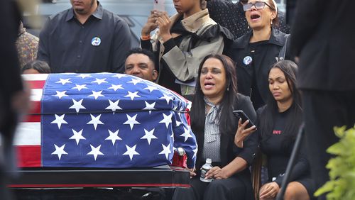 Sandra Garcia, center, sits with other family members as pallbearers carry the casket of her son, Massachusetts State Police recruit Enrique Delgado-Garcia, during his funeral service at the Mercadante Funeral Home in Worcester, Mass., Saturday, Sept. 24, 2024. (John Tlumacki/The Boston Globe via AP)