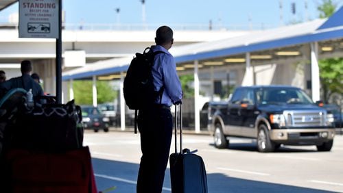 Ride-share pickups at Hartsfield-Jackson International have been moved to the economy lots, requiring longer walks and creating backups at peak times. BRANT SANDERLIN/BSANDERLIN@AJC.COM