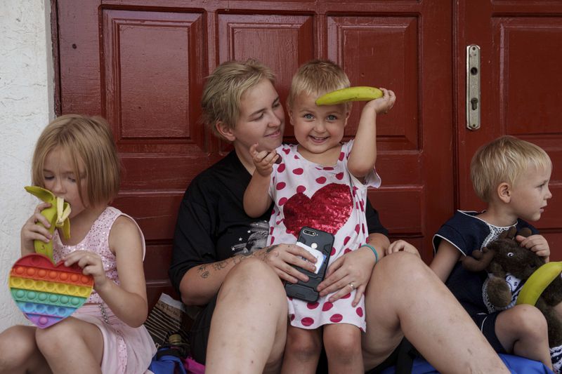 Nadia Trushenko, with her daughters Ksenia, left, Daria, center and Liubov, wait for evacuation in Pokrovsk, Donetsk region, Ukraine, Friday, Aug. 23, 2024. (AP Photo/Evgeniy Maloletka)