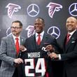 Atlanta Falcons new coach Raheem Morris poses with a Falcons jersey at Mercedes-Benz Stadium, Monday, February 5, 2024, in Atlanta. Also pictured is Falcons president Greg Beadles, left, and general manager Terry Fontenot. (Jason Getz / Jason.Getz@ajc.com)