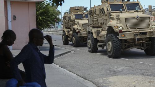 Kenyan police officers, part of a UN-backed multinational force, drive past residents in armored vehicles on the streets of Port-au-Prince, Haiti, Wednesday, Sept. 4, 2024. (AP Photo/Odelyn Joseph)