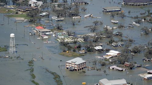 FILE - Buildings and homes are flooded in the aftermath of Hurricane Laura near Lake Charles, La., on Aug. 27, 2020. (AP Photo/David J. Phillip, File)