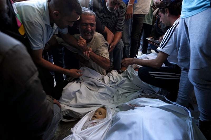 Palestinians mourn for relatives killed in the Israeli bombardment of the Gaza Strip at a hospital morgue in Deir al-Balah, Wednesday, Oct. 2, 2024. (AP Photo/Abdel Kareem Hana)