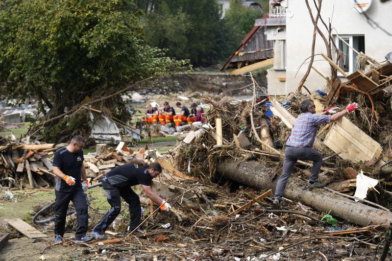 Residents clean up after recent floods in Mikulovice, Czech Republic, Thursday, Sept. 19, 2024. (AP Photo/Petr David Josek)