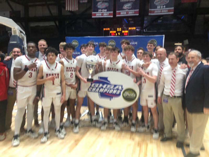 North Oconee's basketball team holds the championship trophy after beating Holy Innocents 65-60 for the Class 4A title, March 6, 2024.