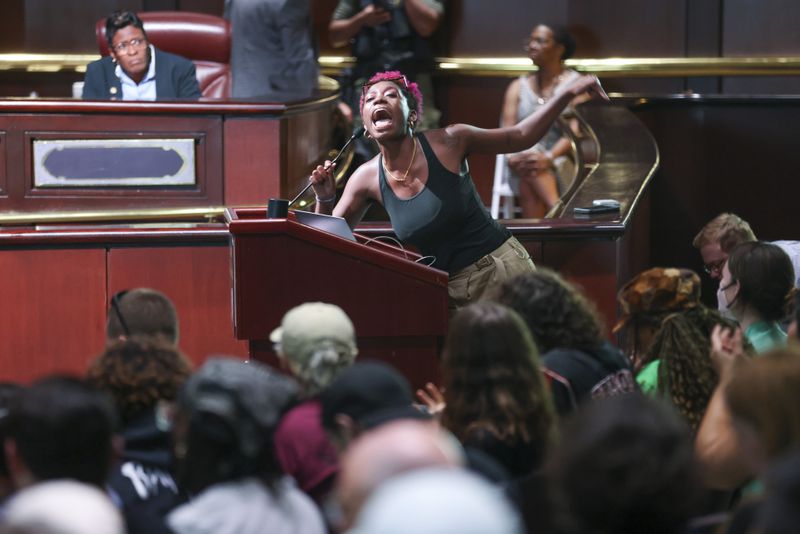 A protestor speaks to fellow protestors during the public comment portion ahead of the final vote to approve legislation to fund the training center at Atlanta City Hall, on Monday, June 5, 2023, in Atlanta. (Jason Getz / Jason.Getz@ajc.com)