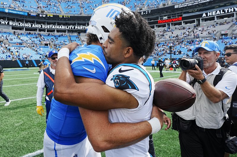 Carolina Panthers quarterback Bryce Young and Los Angeles Chargers quarterback Justin Herbert hug on the field after an NFL football game on Sunday, Sept. 15, 2024, in Charlotte, N.C. (AP Photo/Rusty Jones)