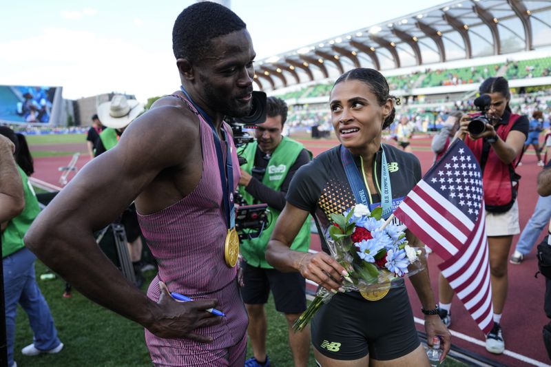 Rai Benjamin, left, speaks with Sydney McLaughlin-Levrone during the U.S. Track and Field Olympic Team Trials, Sunday, June 30, 2024, in Eugene, Ore. (AP Photo/Charlie Neibergall)