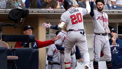 Marcell Ozuna celebrates his solo home run with Dansby Swanson and manager Brian Snitker during the seventh inning of Sunday's game against the Padres in San Diego. (AP Photo/Kyusung Gong)