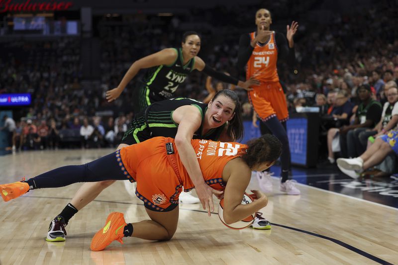 Connecticut Sun guard Veronica Burton (22) tries to call for a timeout after gaining possession of the ball against Minnesota Lynx forward Bridget Carleton (6) during the second half of Game 1 of a WNBA basketball semifinals series Sunday, Sept. 29, 2024, in Minneapolis. (AP Photo/Stacy Bengs)