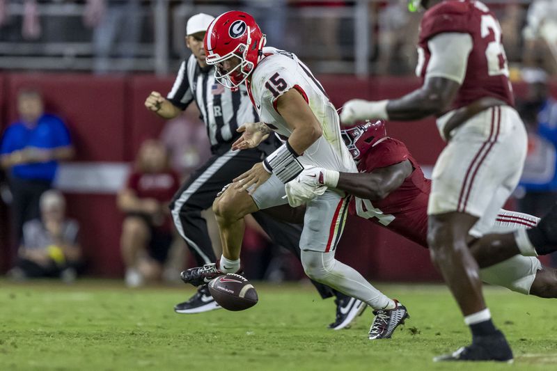 Alabama linebacker Qua Russaw (4) forces a fumble from Georgia quarterback Carson Beck (15) during the second half of an NCAA college football game, Saturday, Sept. 28, 2024, in Tuscaloosa, Ala. (AP Photo/Vasha Hunt)