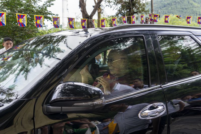 Tibetan spiritual leader the Dalai Lama greets a welcoming crowd from inside his car on his arrival in Dharamshala, India, Wednesday, Aug. 28, 2024. (AP Photo/Ashwini Bhatia)