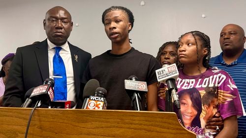 Malachi Hill Massey, 17, center, speaks at a news conference on Tuesday, July 23, 2024, at the NAACP headquarters in Springfield, Ill., about his mother, Sonya Massey, who was shot to death by a Sangamon County Sheriff's deputy on July 6 in Springfield after calling 911 for help. On the left is civil right attorney Ben Crump, who is representing the Massey family. On the right is Sonya Massey's daughter, Jeanette Summer Massey, 15. (AP Photo/John O'Connor)