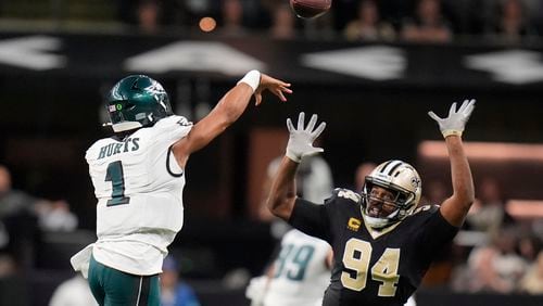 Philadelphia Eagles quarterback Jalen Hurts (1) passes over the reach of New Orleans Saints defensive end Cameron Jordan (94) in the second half of an NFL football game in New Orleans, Sunday, Sept. 22, 2024. (AP Photo/Gerald Herbert)