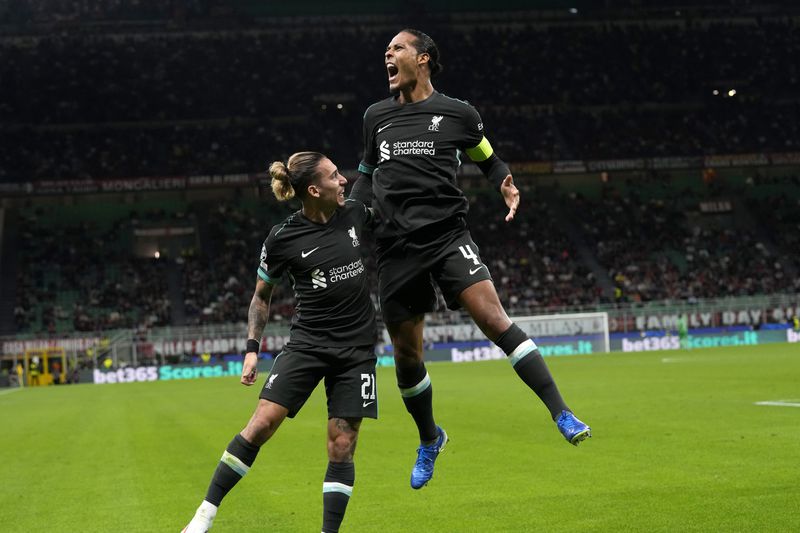 Liverpool's Virgil van Dijk, left, celebrates after scoring his side's second goal during the Champions League opening phase soccer match between AC Milan and Liverpool at the San Siro stadium in Milan, Italy, Tuesday, Sept. 17, 2024. (AP Photo/Antonio Calanni)