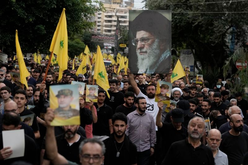 Hezbollah supporters carry pictures of Hezbollah commander Ibrahim Akil and Supreme Leader Ayatollah Ali Khamenei during Akil's funeral procession in Beirut's southern suburb, Sunday, Sept. 22, 2024. (AP Photo/Bilal Hussein)