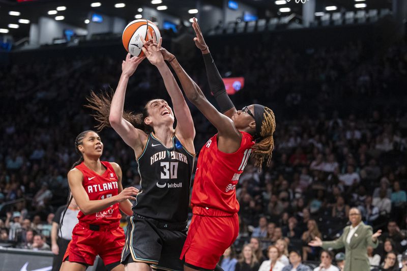 New York Liberty forward Breanna Stewart (30) is defended by Atlanta Dream guard Rhyne Howard (10) during the first half of a WNBA basketball first-round playoff game Sunday, Sept. 22, 2024, in New York. (AP Photo/Corey Sipkin)