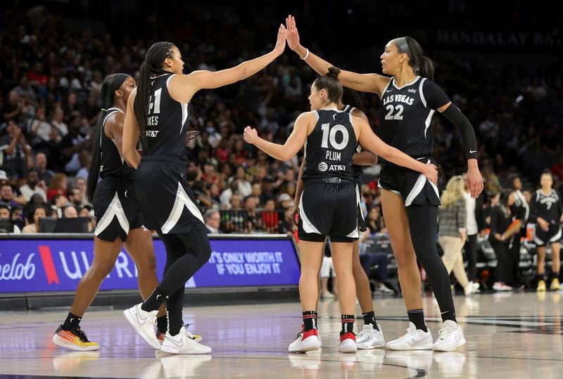 Las Vegas Aces center A'ja Wilson (22) is congratulated by teammates Kiah Stokes (41) and Kelsey Plum (10) after scoring a basket and drawing a foul during the first half of an WNBA basketball game against the Seattle Storm Wednesday, June 19, 2024, in Las Vegas. (Steve Marcus/Las Vegas Sun via AP)