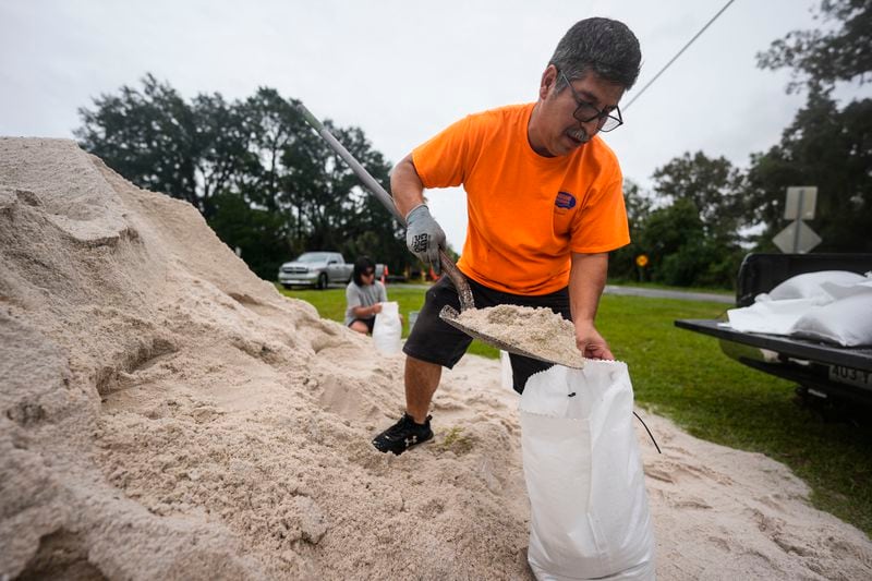 Jose Gonzales and his son Jadin Gonzales, 14, fill sand bags ahead of Hurricane Helene, expected to make landfall Thursday evening, Thursday, Sept. 26, 2024, in Clyattville, Ga. (AP Photo/Mike Stewart)