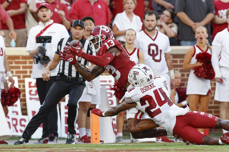 Oklahoma wide receiver J.J. Hester (13) misses a catch in the end zone as Temple cornerback Ben Osueke (24) pressures him during the second quarter of an NCAA college football game Friday, Aug. 30, 2024, in Norman, Okla. (AP Photo/Alonzo Adams)