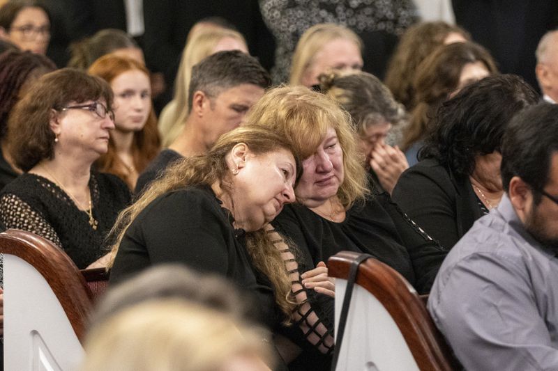 Mourners grieve for Ana Cristina Irimie, a math teacher killed during a shooting at Apalachee High School, during her funeral service at Hamilton Mill Memorial Chapel and Gardens in Buford, Ga., on Saturday, Sept. 14, 2024. (Arvin Temkar/Atlanta Journal-Constitution via AP)