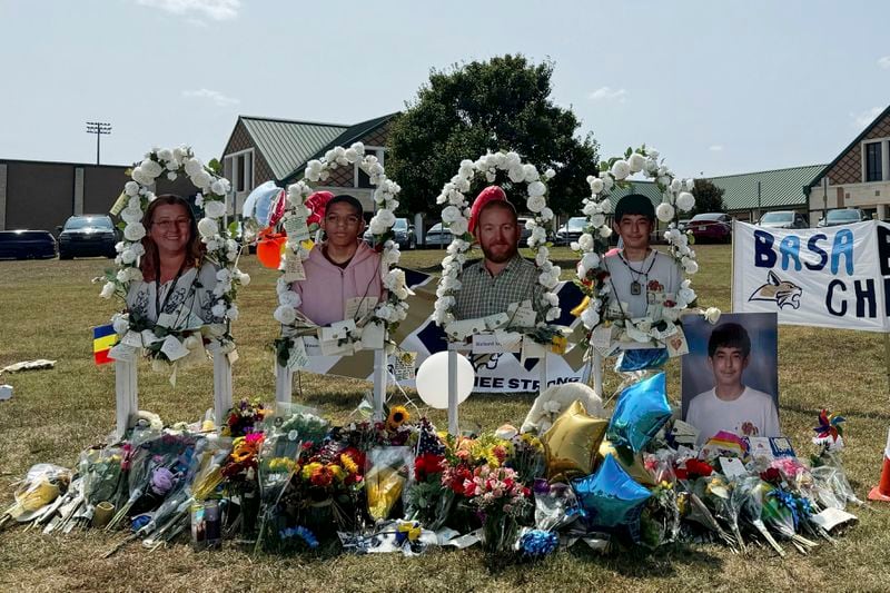 A poster with images of shooting victims from left, Cristina Irimie, Mason Schermerhorn, Richard Aspinwall and Christian Angulo is displayed at a memorial outside Apalachee High School, Tuesday, Sept. 10, 2024, in Winder, Ga. (AP Photo/Charlotte Kramon)